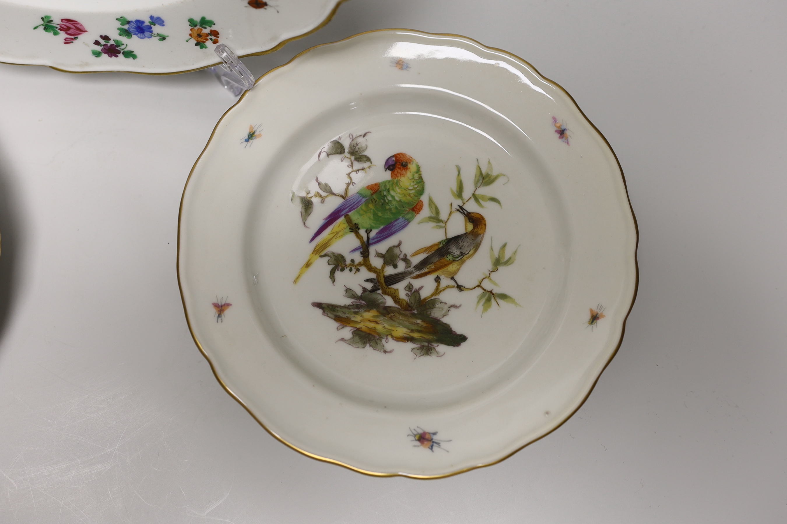 A Meissen plate with crown and fish crest boldly painted with flowers, crossed swords in blue, and four smaller plates painted with birds, probably 19th century German, 24cm in diameter